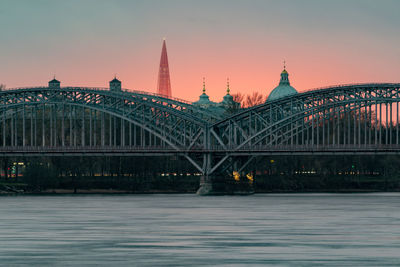 Bridge over river against sky during sunset