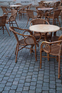 Empty chairs and tables at sidewalk cafe