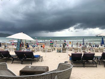 Chairs and tables on beach against sky