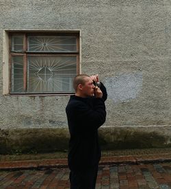 Full length of boy standing against wall