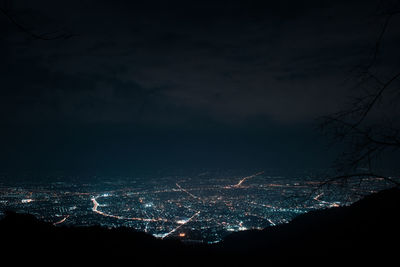 Illuminated cityscape against sky at night
