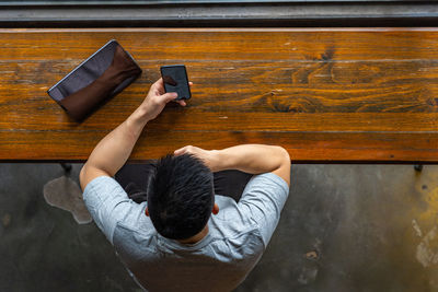 High angle view of man photographing with mobile phone