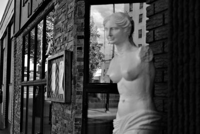 Side view of woman standing by window