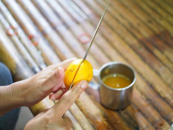 Close-up of hand holding drink on table