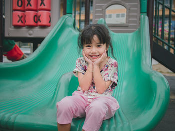 Portrait of a smiling girl sitting outdoors