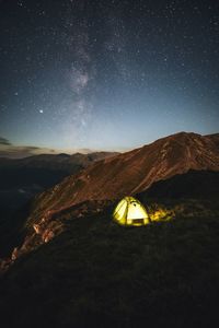 Scenic view of nightscape and illuminated tent under the milky way in the fagaras mountains