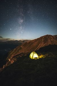 Scenic view of illuminated land against sky at night