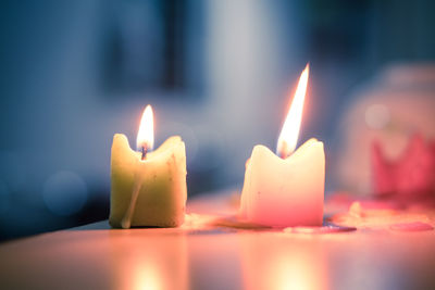 Close-up of lit candles on table