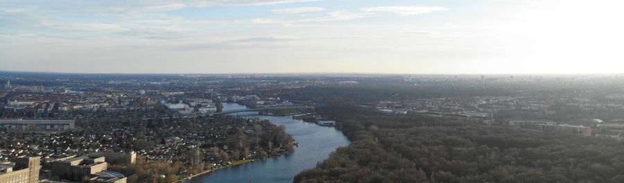 High angle view of townscape by river against sky