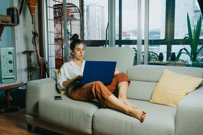 Full length of woman using laptop at home