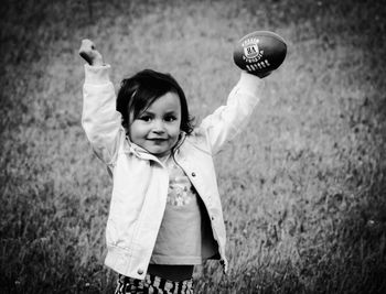 Portrait of girl playing on grassy field