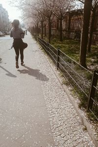 Full length of woman walking on footpath