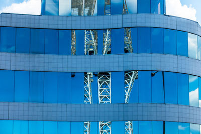 Low angle view of modern glass building against blue sky