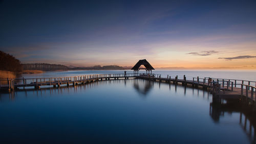 Pier over sea against sky during sunset