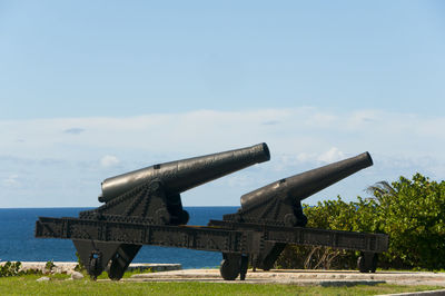 Cannons on field against blue sky