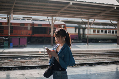 Woman standing on railroad station platform