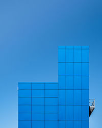 Low angle view of modern building against clear blue sky