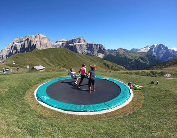 People on mountain against clear blue sky