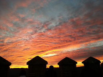 Buildings against cloudy sky during sunset