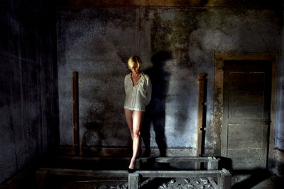 Full length of woman standing in abandoned building