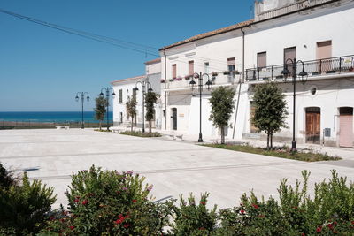 Street by buildings against clear sky