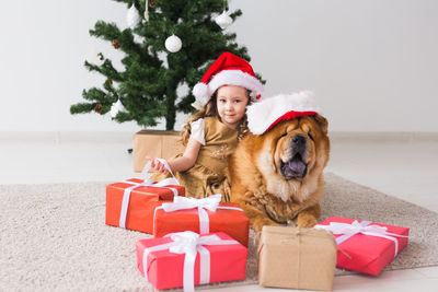 Portrait of man with dog sitting in box