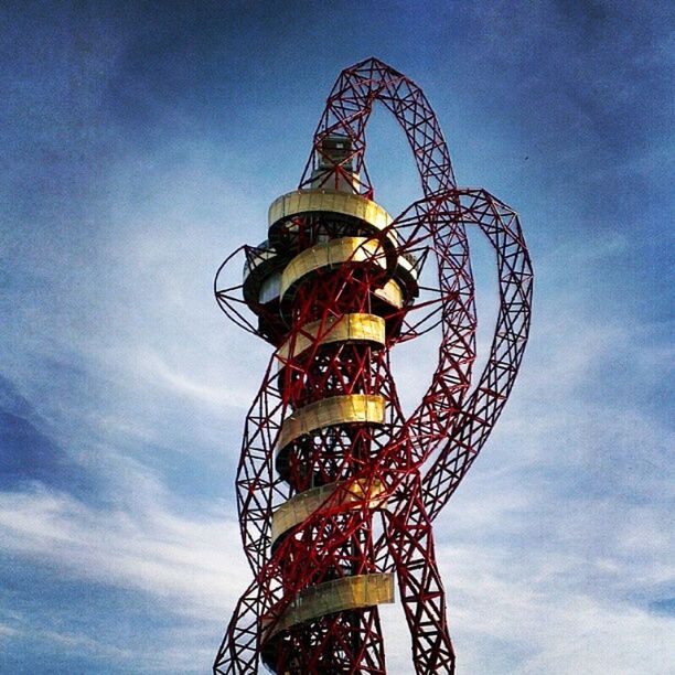 low angle view, amusement park, amusement park ride, sky, ferris wheel, arts culture and entertainment, cloud - sky, built structure, tall - high, tower, architecture, blue, metal, cloud, cloudy, outdoors, fun, day, no people, illuminated