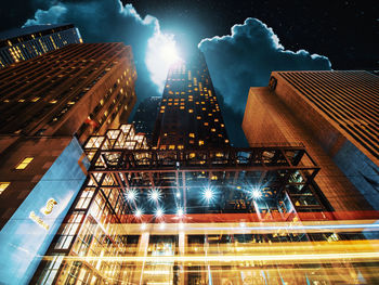 Low angle view of illuminated buildings against sky at night