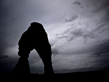 Low angle view of silhouette man against cloudy sky