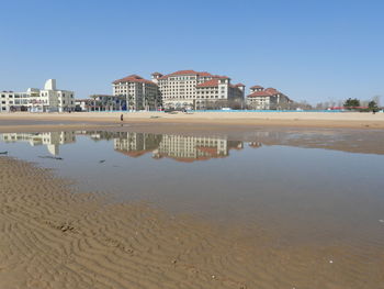 View of beach by buildings against sky