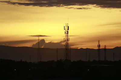 Silhouette communications tower against sky during sunset