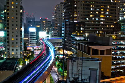 High angle view of light trails on street amidst buildings at night