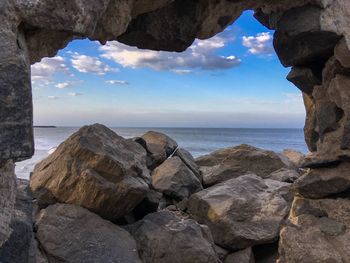 Rock formations by sea against sky