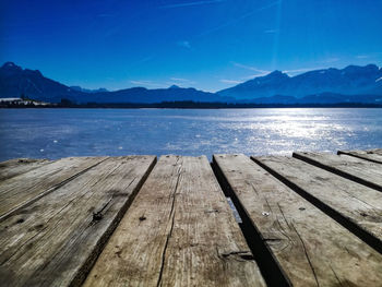 Pier over lake against blue sky