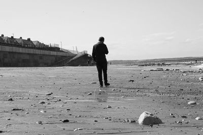 Rear view full length of man walking at beach