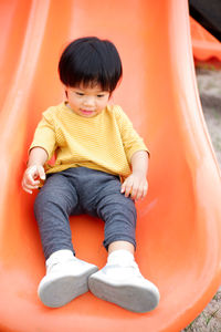Portrait of cute boy sitting on sofa at home