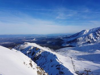 Scenic view of snowcapped mountains against blue sky