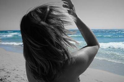 Close-up of young woman at beach against clear sky