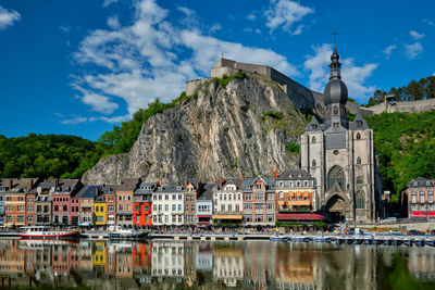 Buildings by river against sky