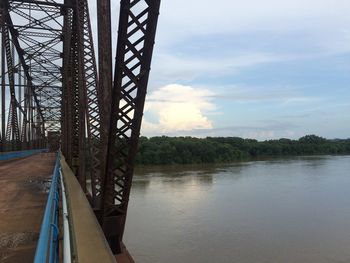 Bridge over river against cloudy sky