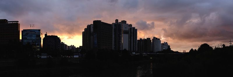 Silhouette buildings against sky during sunset