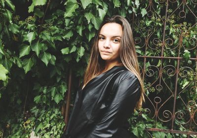 Portrait of woman standing against plants