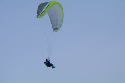 Low angle view of person paragliding against clear sky