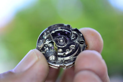 Close-up of human hand holding gears