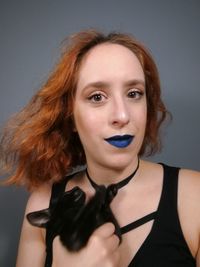 Portrait of beautiful woman against gray background