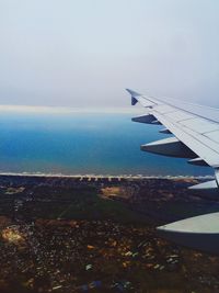 Cropped image of airplane flying over sea