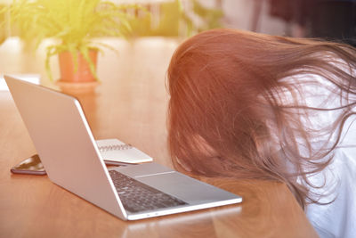 Midsection of woman using smart phone on table