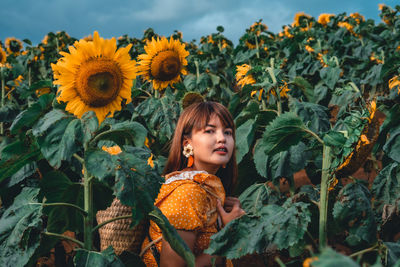 Portrait of girl with sunflowers in background