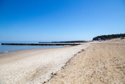 Scenic view of beach against clear blue sky