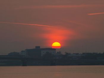 Silhouette buildings against sky during sunset